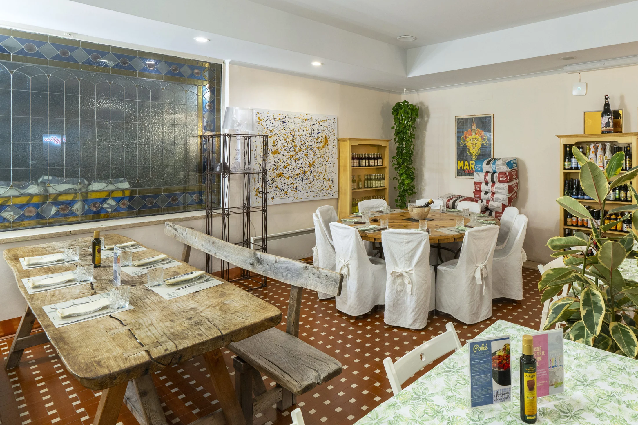 Sala con tavoli rustici e opere alle pareti